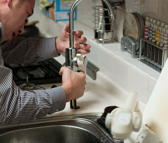 Plumber repairs faucet